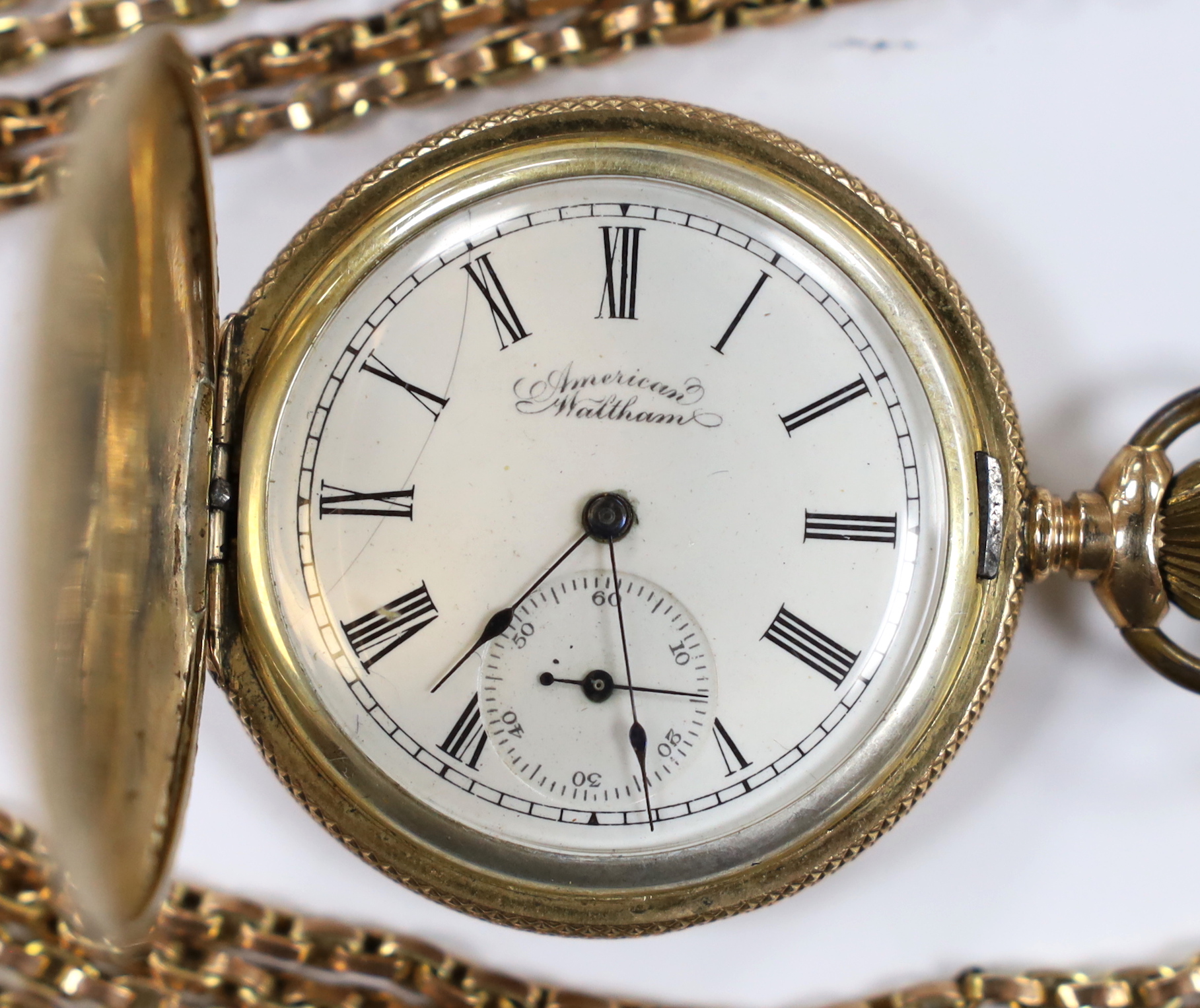An American Waltham engraved gold plated hunter pocket watch, case diameter 42mm, together with a 9ct double strand chain, 39cm, chain 29.6 grams.